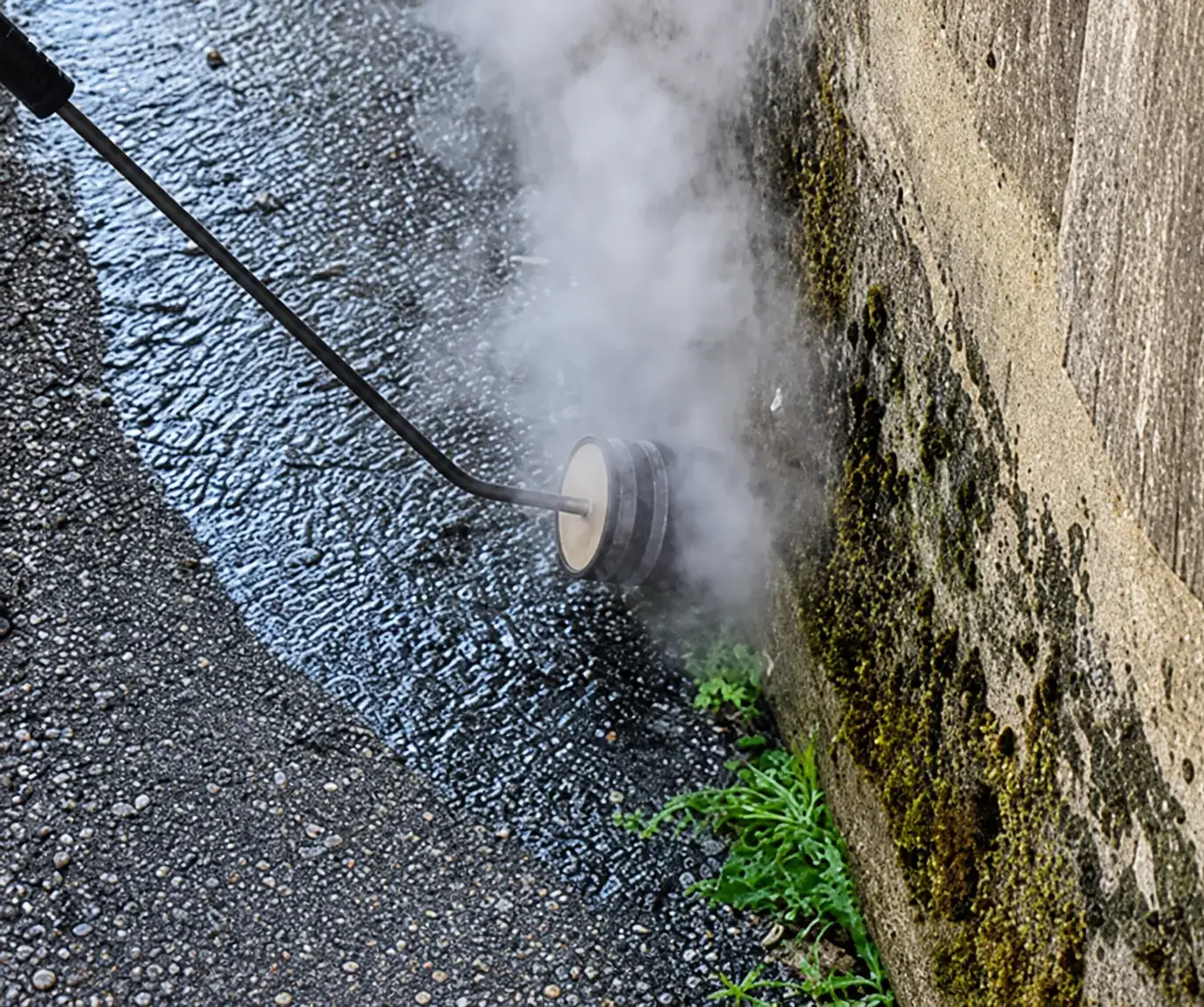 Thermische Unkrautvernichtung ohne Chemie mit heißem Wasser auf einer Pflasterfläche in Kärnten